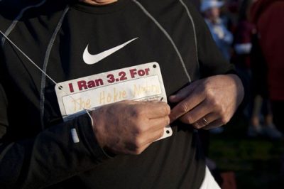 A participant attaches a bib before the start of the 3.2 Mile Run in Remembrance.