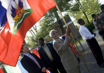 Haitian Ambassador Raymond Joseph cheers on the runners outside the Cranwell International Center.